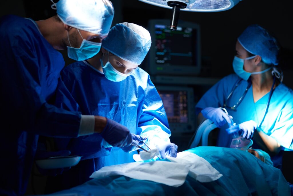 Surgeons performing an operation in a hospital operating room under bright surgical lights