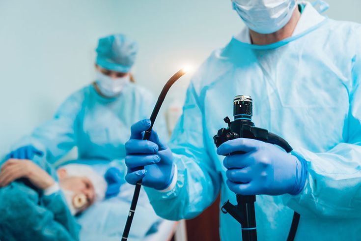 Doctors preparing endoscope for a medical procedure."